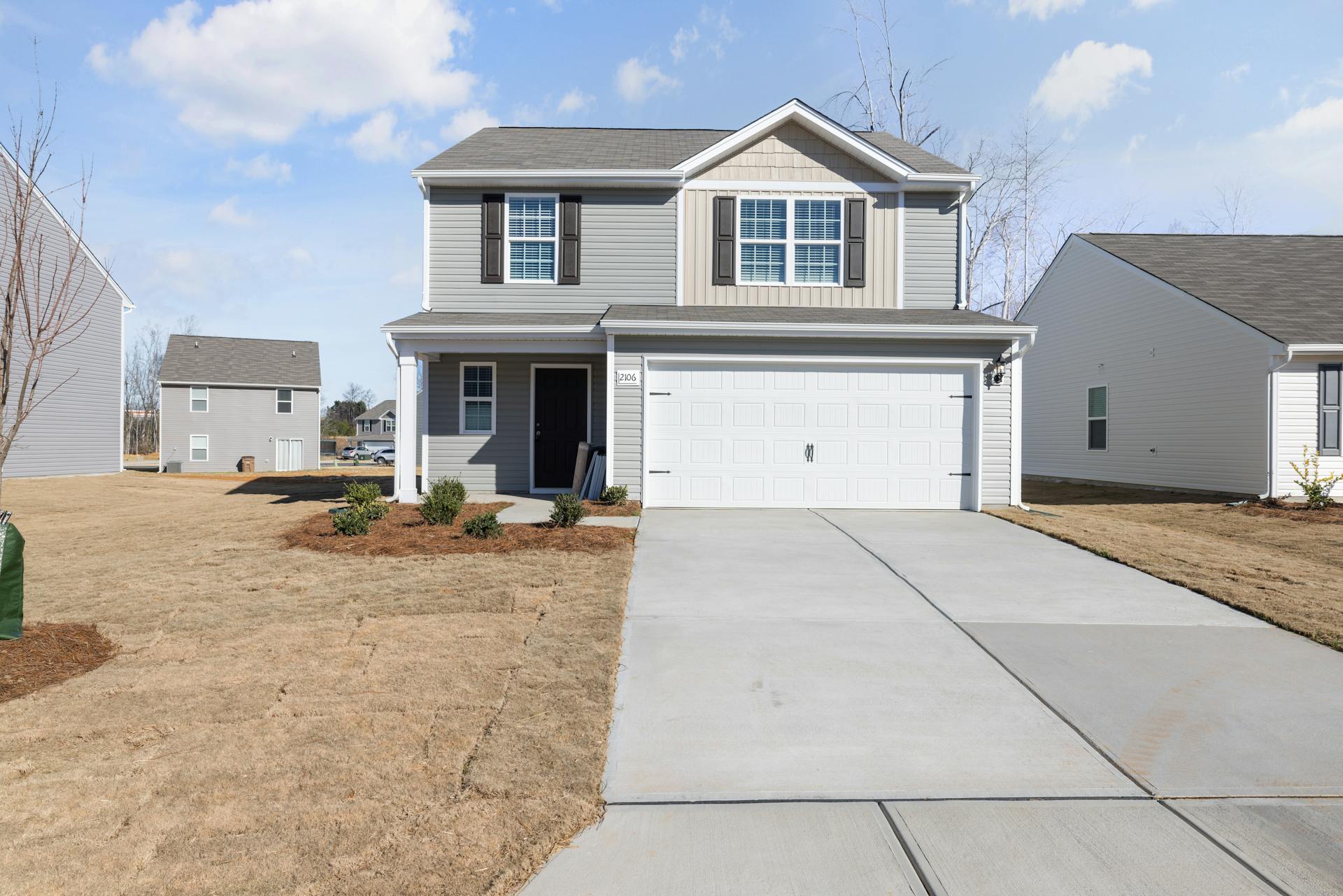 New two-storey home with vinyl siding and an attached garage in a growing subdivision