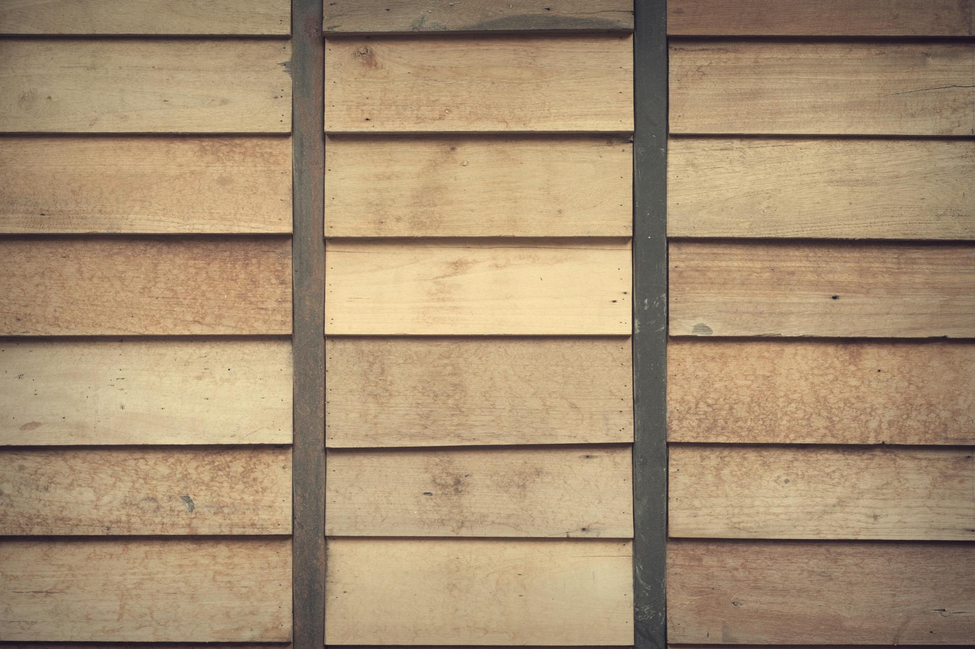 Weathered horizontal wood siding boards with dark vertical battens