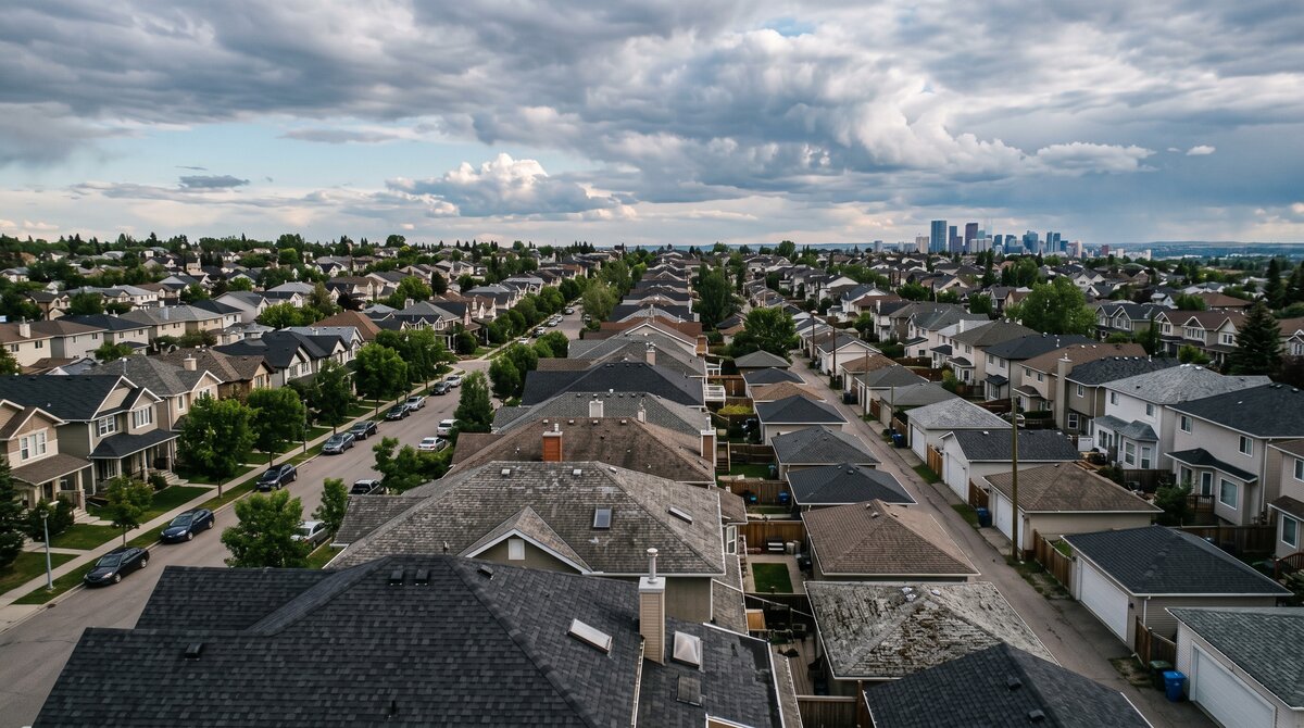 Aerial view of asphalt shingle rooftops across a Calgary neighbourhood showing roofs of varied ages and condition